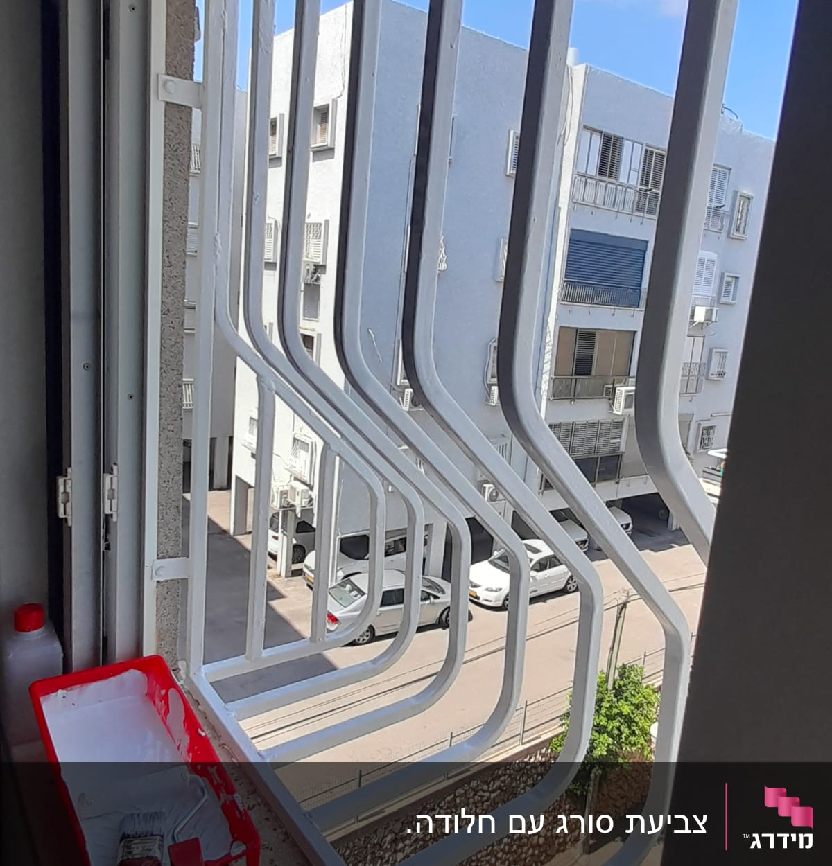 מגש צבע אדום עם מברשת על אדן חלון